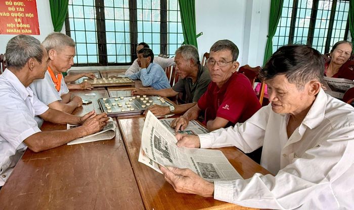 Cụ Đào Văn Bộ (thôn Hoa Lư, xã Cát Tiên 3) đang đọc báo, trong khi các bạn của cụ chơi cờ an hưởng tuổi già thảnh thơi, vui vẻ.