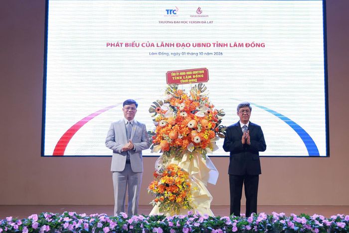 Đồng chí Nguyễn Minh, Tỉnh ủy viên, Phó Chủ tịch UBND tỉnh Lâm Đồng (bên phải) tặng lẵng hoa chúc mừng Trường Đại học Yersin Đà Lạt