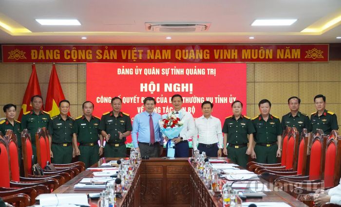 Các đại biểu tặng hoa, chụp ảnh lưu niệm với đồng chí Vương Quốc Tuấn, Bí thư Đảng ủy Quân sự tỉnh - Ảnh: X.P