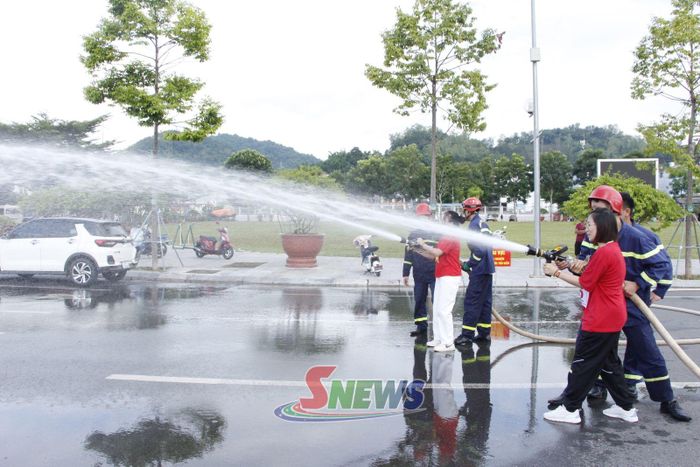 Cán bộ chiến sĩ Phòng Cảnh sát PCCC và CNCH hướng dẫn nhân dân thực hành phun nước chữa cháy.