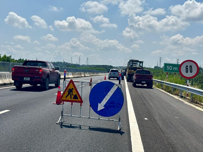 Trong lúc công trường khẩn trương xử lý mặt đường, bên ngoài khu vực thi công, dòng xe vẫn nối nhau lưu thông trên cao tốc. Khi đến vị trí có biển cảnh báo, các phương tiện giảm tốc độ, di chuyển qua phần đường được phân luồng rồi tiếp tục hành trình. Lực lượng cảnh sát giao thông cũng có mặt tại hiện trường, phối hợp theo dõi tình hình và điều tiết phương tiện, hạn chế nguy cơ xung đột giữa xe đang lưu thông với máy móc, nhân công thi công.