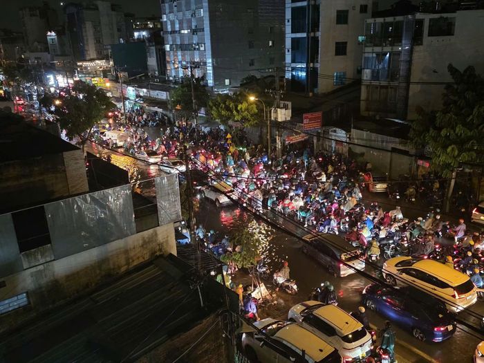 Tại một số khu vực trên quốc lộ 13, dòng xe nối dài, nhiều thời điểm gần như đứng yên. Người đi xe máy phải dò từng chút qua những đoạn nước ngập, trong điều kiện trời vẫn mưa lớn. Tình trạng ngập nước cũng khiến việc di chuyển của xe buýt và ô tô gặp khó khăn. Các phương tiện phải giảm tốc độ, tránh những vị trí nước sâu, khiến ùn tắc càng kéo dài (Ảnh: Hoàng Trường).