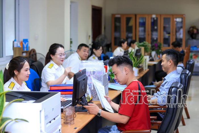 Cán bộ thuế hướng dẫn thủ tục cho hộ kinh doanh. Ảnh Đức Thanh