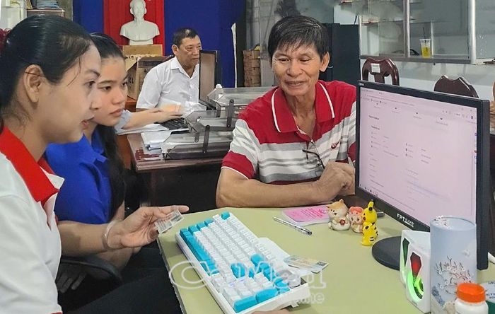 Chị Nguyễn Phương Tú (bìa trái), từng là Phó Bí thư Ðoàn Phường 9, nay đảm nhận vị trí Trưởng ban Công tác Mặt trận Khóm 6, phường An Xuyên, hướng dẫn người dẫn thực hiện thủ tục hành chính trên môi trường điện tử.