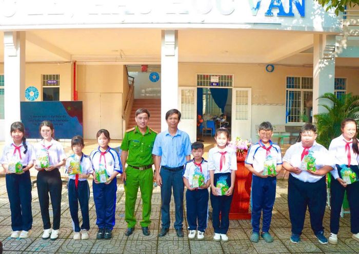Đại diện Công an xã Đất Đỏ trao học bổng, tặng quà cho các em học sinh