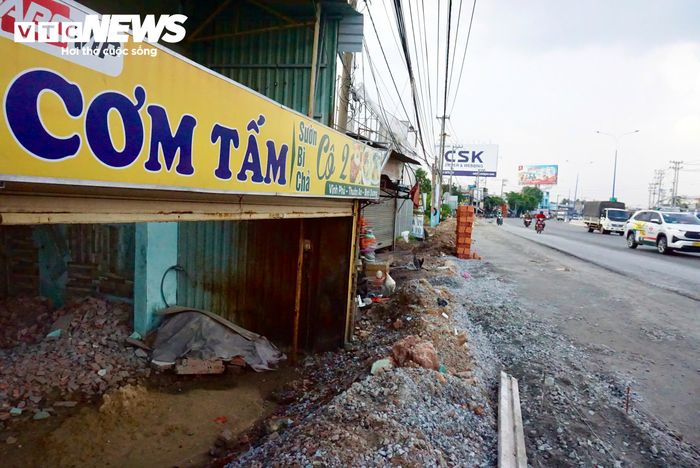 Sự chênh lệch cao độ thể hiện rõ tại nhiều căn nhà dọc tuyến. Một quán cơm nằm sát Quốc lộ 13 trở nên thấp rõ rệt so với mặt đường. Nhìn từ bên ngoài, mái che và biển hiệu gần ngang với tầm nhìn của người đi trên phần đường mới được nâng nền. Chủ quán phải đóng cửa, thuê đội thi công đến nâng cấp nền nhà.