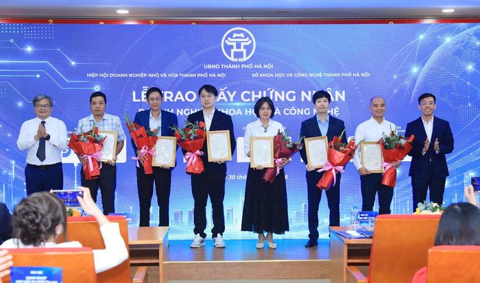 Phó Chủ tịch UBND thành phố Hà Nội Trương Việt Dũng trao giấy chứng nhận cho các doanh nghiệp khoa học và công nghệ. Ảnh: Xuân Hải