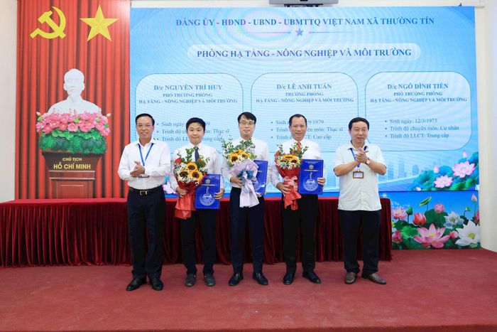 Các đồng chí lãnh đạo xã Thường Tín tặng hoa và trao quyết định cho lãnh đạo Phòng Hạ tầng - Đô thị & Môi trường. Ảnh: PV