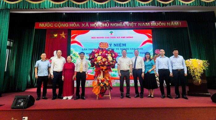 Lãnh đạo xã Phù Đổng tặng hoa chúc mừng Hội Người cao tuổi xã nhân kỷ niệm Ngày Quốc tế Người cao tuổi. Ảnh PV