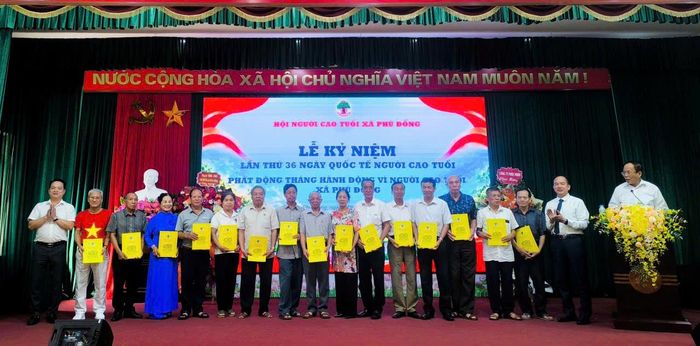 Lãnh đạo xã Phù Đổng trao quà cho người cao tuổi có hoàn cảnh khó khăn. Ảnh PV