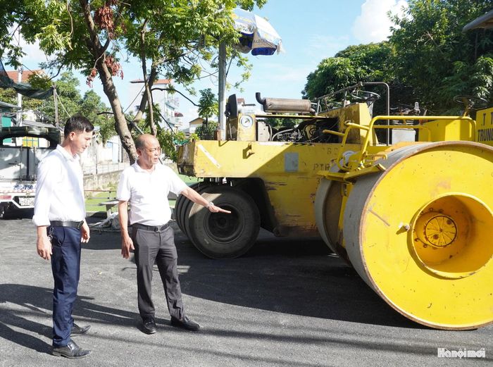 Giám đốc Ban Quản lý dự án đầu tư - hạ tầng xã Dân Hòa Nguyễn Đăng Toàn Thắng cùng đại diện doanh nghiệp tại công trình đường dân sinh ở thôn Vũ Lăng. Ảnh: Lê Dung