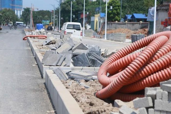 Vật liệu xây dựng cùng hệ thống ống nhựa luồn cáp viễn thông, điện ngầm được tập kết ngay sát mép vỉa hè.