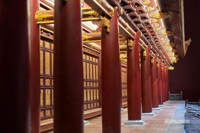 Hàng cột sơn son chạy dọc hiên điện tạo nhịp kiến trúc liên tục, nâng đỡ hệ mái phía trên. Ảnh: T.Anh.