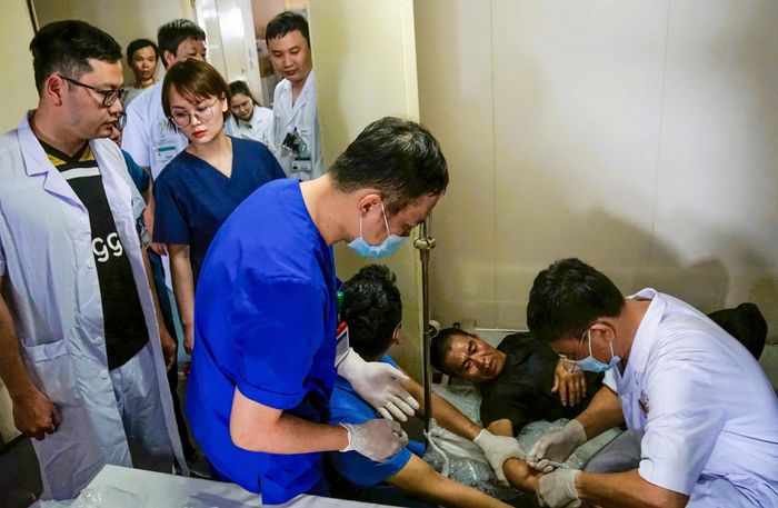 Bác sĩ Nguyễn Hưng Đạo (áo trắng) can thiệp, bó bột cho người dân bị chấn thương cánh tay tại tàu HQ-561. Ảnh: Minh Lý