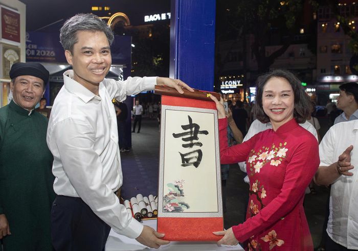 Đoàn đại biểu tham quan gian hàng thư pháp tại Hội Sách. Hội Sách Hà Nội năm 2026 có nhiều hoạt động trải nghiệm văn hóa như viết thư pháp, in rập họa tiết bia tiến sĩ...
