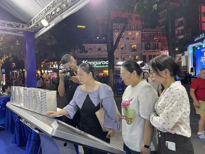 khách tham quan, trải nghiệm tại không gian "Sách mở tri thức - Công nghệ dẫn tương lai”. Ảnh: Tuyết Mai - TTXVN