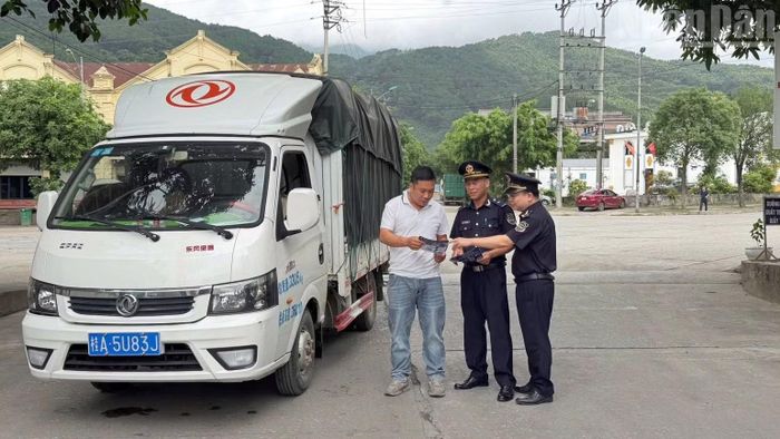 Cán bộ Hải quan tuyên truyền các chính sách pháp luật mới cho lái xe Trung Quốc. (Ảnh: QUỐC ĐẠT)