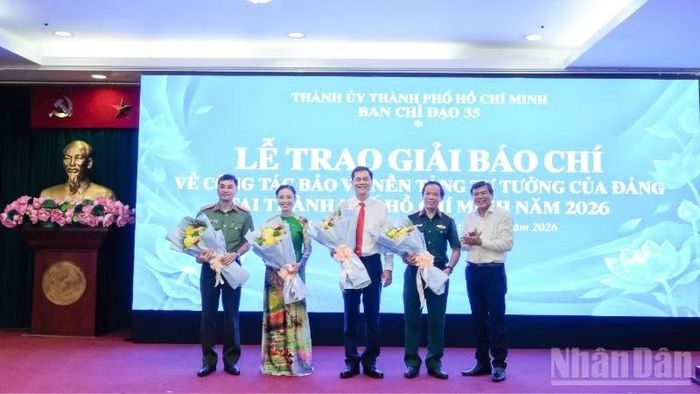Phó Trưởng Ban Tuyên giáo Thành ủy Tăng Hữu Phong tặng hoa cho các đại biểu, tác giả tham gia buổi giao lưu. (Ảnh: THẾ ANH)