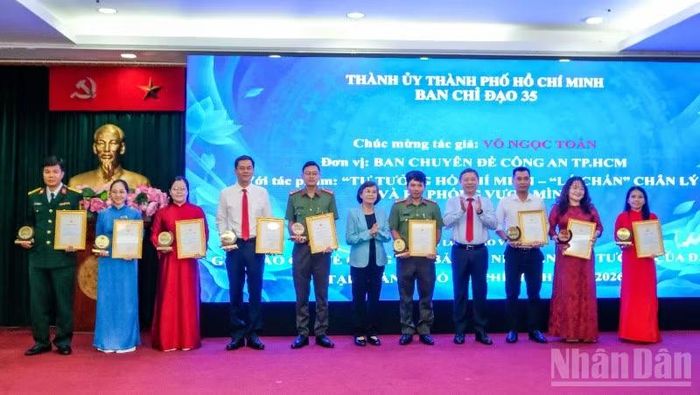 Đồng chí Phạm Phương Thảo, nguyên Phó Bí thư Thành ủy, nguyên Chủ tịch Hội đồng nhân dân Thành phố Hồ Chí Minh, đồng chí Dương Anh Đức, Trưởng Ban Tuyên giáo Thành ủy trao giải cho các tác giả đoạt giải ở thể loại báo viết. (Ảnh: THẾ ANH)