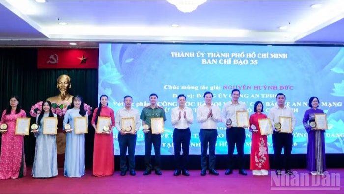 Đồng chí Lê Quốc Phong, Phó Bí thư Thường trực Thành ủy Thành phố Hồ Chí Minh (thứ 5 từ phải qua), đồng chí Nguyễn Huy Ngọc, Vụ trưởng Vụ Địa phương 3, Ban Tuyên giáo Trung ương trao giải cho các tác giả đoạt giải ở thể loại tạp chí. (Ảnh: THẾ ANH)