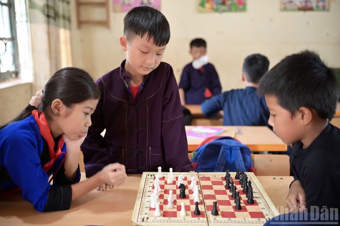 Không có đồng hồ thi đấu, thầy giáo Trứ thường dùng hai chiếc điện thoại di động để các em thay nhau bấm giờ, tính điểm. Cách làm này thậm chí còn có thể áp dụng với nội dung cờ chớp. (Ảnh: LINH PHAN)