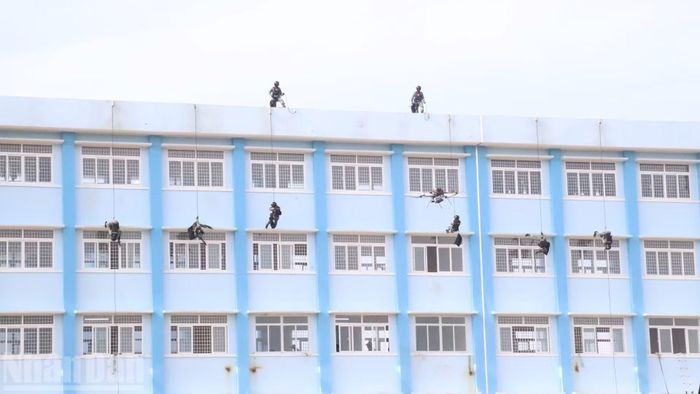Lực lượng đặc nhiệm đu dây từ mái nhà xuống xâm nhập các tầng khống chế các đối tượng khủng bố. (Ảnh: CÔNG LÝ)