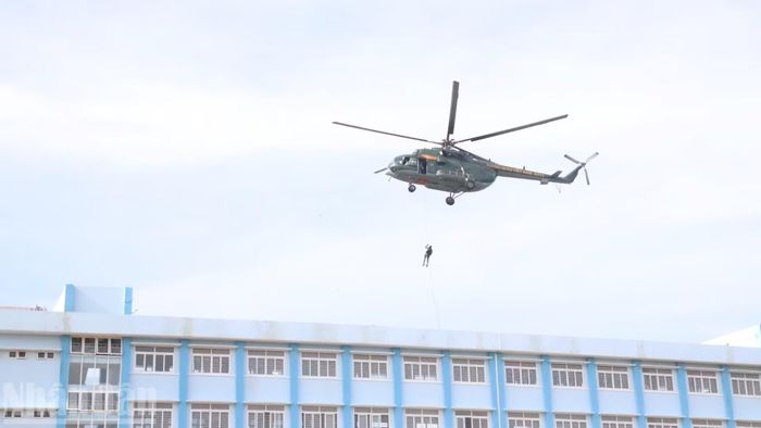 Lực lượng đặc nhiệm đu dây từ trực thăng xuống nhà cứu con tin. (Ảnh: CÔNG LÝ)