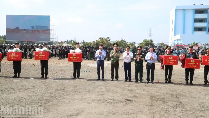 Các đồng chí lãnh đạo Bộ Công an và tỉnh Đắk Lắk tặng hoa và quà cho các đơn vị tham gia diễn tập. (Ảnh: CÔNG LÝ)