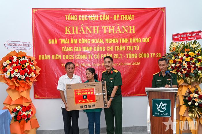   Đại tá Trần Doãn Thoan, Phó tổng giám đốc Tổng công ty 28 trao quà của Tổng công ty tặng gia đình đồng chí Trần Thị Tú. 