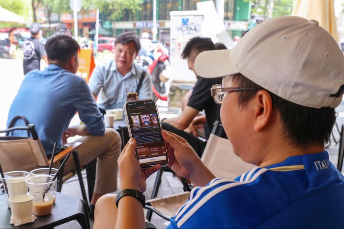 Một người đàn ông xem phim ngắn AI tại quán cà phê Góc trên đường Huỳnh Thúc Kháng, phường Sài Gòn, TPHCM. Ảnh: HOÀNG TRIỀU