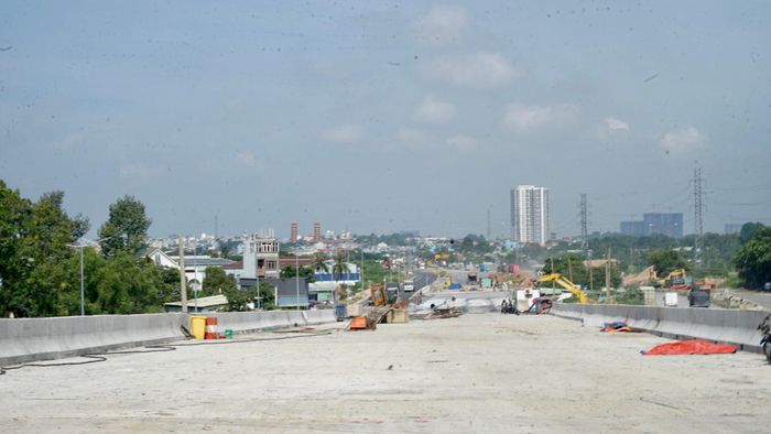  Cầu vượt tại nút giao Tân Vạn kết nối với đường Mỹ Phước - Tân Vạn chuẩn bị thảm bê tông nhựa. Ảnh: DUY TRẦN 