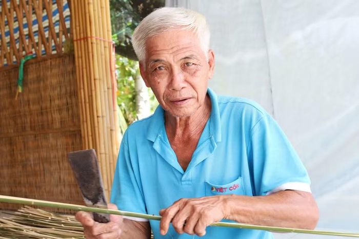 Ông Phạm Đạt ngồi vót nan.
