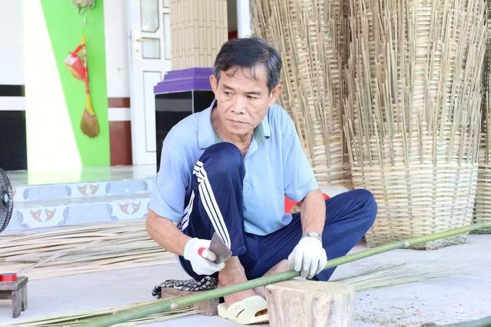 Một nhân công đang chẻ trúc.