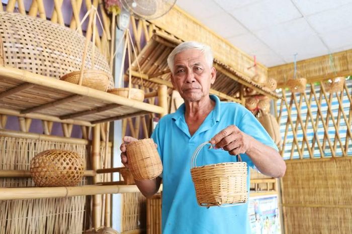 Ông Phạm Đạt giới thiệu sản phẩm đan đát tại khu trưng bày làng nghề.