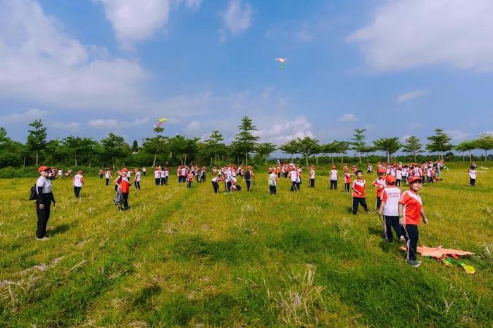 Học sinh hào hứng chạy trên đồng, đưa những cánh diều lên cao.