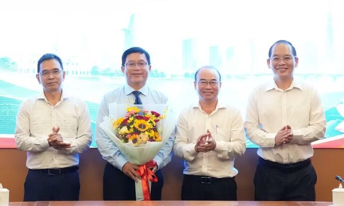 Lãnh đạo nhà trường tặng hoa chúc mừng PGS.TS Lê Tuấn Anh. Ảnh: TDMU.