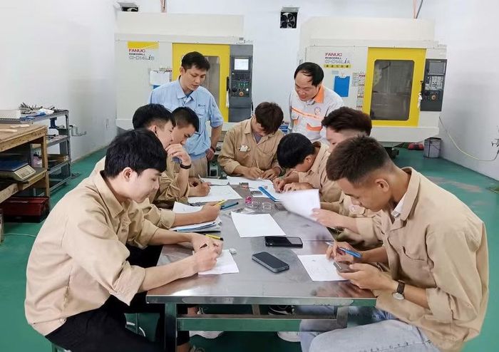Giáo viên Trường Cao đẳng Công nghiệp Huế hướng dẫn sinh viên vừa học lý thuyết và thực hành tại xưởng ở trường.