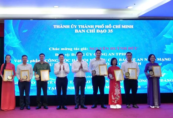 Ông Lê Quốc Phong (thứ 5 từ phải qua) - Phó Bí thư Thường trực Thành ủy, Trưởng Ban Chỉ đạo 35 Thành ủy TPHCM, cùng các đại biểu trao thưởng cho các tác giả đạt thành tích cao trong cuộc thi.