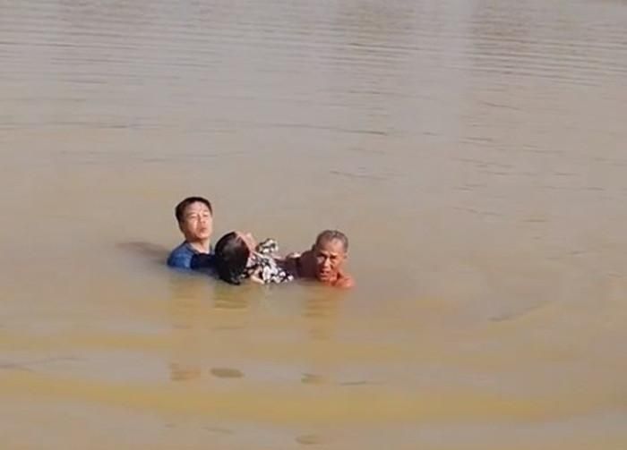 Thượng tá Diệt (áo xanh) cùng người dân cứu nạn nhân. Ảnh cắt từ clip