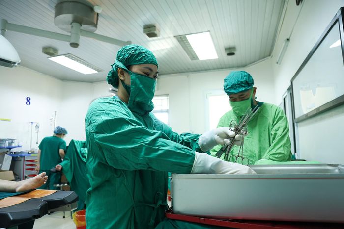 Tôi kiểm tra các dụng cụ phẫu thuật như dao, kéo để bảo đảm mọi thứ đã sẵn sàng cho ca mổ. Khi công tác chuẩn bị hoàn tất, chiếc đèn trên bàn mổ được bật sáng. Tôi cùng kíp mổ bắt đầu công việc.
