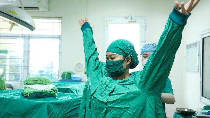 Kíp trực kiểm tra máy móc, theo dõi các chỉ số của mẹ và thai nhi đảm bảo hoạt động bình thường trước khi ca mổ bắt đầu. Điều dưỡng hỗ trợ tôi mang áo choàng phẫu thuật.