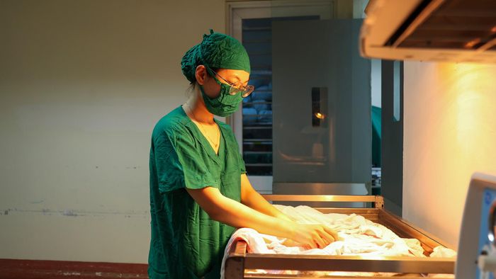 Sát khuẩn tay xong, tôi bước vào phòng mổ. Lúc này, sản phụ đã được đưa vào phòng và gây mê. Điều dưỡng cũng đã chuẩn bị sẵn quần áo, chăn, tất cho em bé.