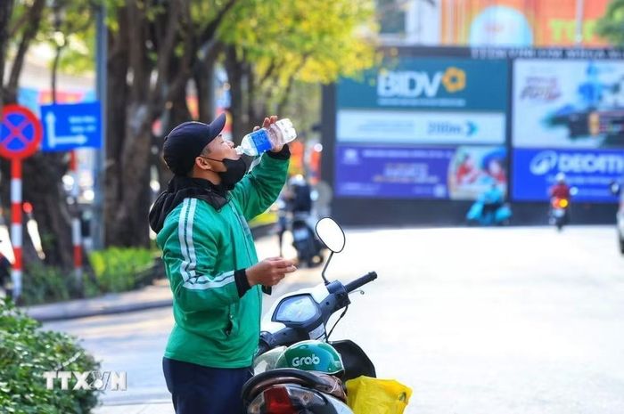 Phút nghỉ ngơi hiếm hoi của một tài xế công nghệ. (Ảnh: Tuấn Anh/TTXVN)