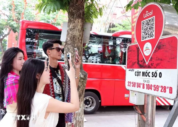 Du khách quét QR tại Km0 tìm hiểu thông tin du lịch. (Ảnh: Đức Thọ/TTXVN)