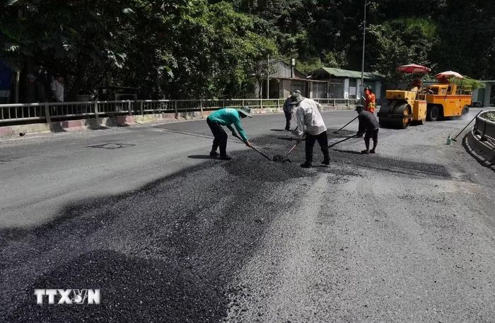 Các tốp công nhân cùng trang thiết bị xe cơ giới khẩn trương thi công khắc phục tình trạng xuống cấp dọc tuyến đèo Bảo Lộc (thuộc Quốc lộ 20, đoạn qua Lâm Đồng). (Ảnh: Nguyễn Dũng/TTXVN)