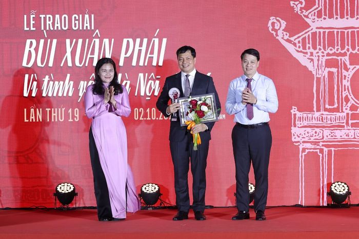 Tiến sỹ Phạm Tuấn Long, Giám đốc Sở Văn hóa, Thể thao và Du lịch Hà Nội và bà Nguyễn Thị Sự, Phó Tổng Giám đốc Thông tấn xã Việt Nam trao Giải Việc làm cho Tiến sỹ Lê Xuân Kiêu, Giám đốc Trung tâm Hoạt động Văn hóa Khoa học Văn Miếu Quốc Tử Giám. (Ảnh: BTC)