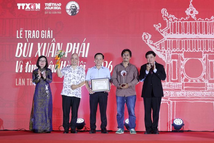 Phó Giáo sư-Tiến sỹ nhà văn Nguyễn Thế Kỷ, nguyên Phó Chủ tịch Hội đồng Lý luận Trung ương, Chủ tịch Hội đồng Giám khảo và Phó Tổng Giám đốc Thông tấn xã Việt Nam Đoàn Thị Tuyết Nhung trao giải cho êkip sáng tạo vở cải lương “Người con gái Hà Thành.” (Ảnh: BTC)