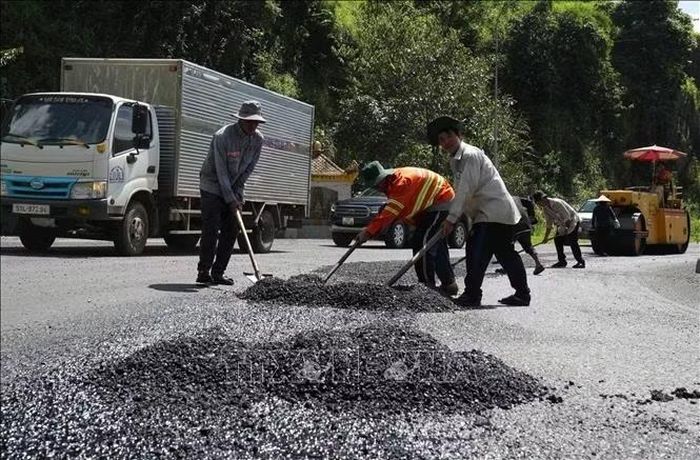 Nhóm công nhân thi công dặm vá mặt đường đèo Bảo Lộc, đoạn trước Miếu Ba Cô (thuộc phường 3 Bảo Lộc, Lâm Đồng).