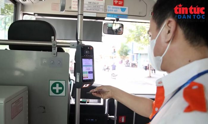 Nhân viên xe buýt xác thực lượt đi của hành khách.