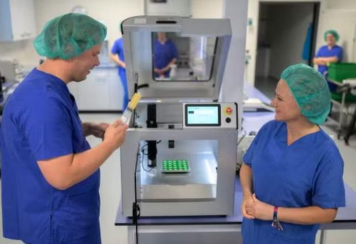 Hai nhà nghiên cứu giới thiệu máy in 3D sản xuất dược phẩm tại một phòng lab ở Oldenburg, Đức. Ảnh: DPA